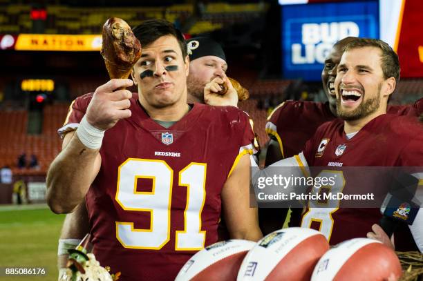 Quarterback Kirk Cousins and outside linebacker Ryan Kerrigan of the Washington Redskins eat turkey after the Redskins defeated the New York Giants...