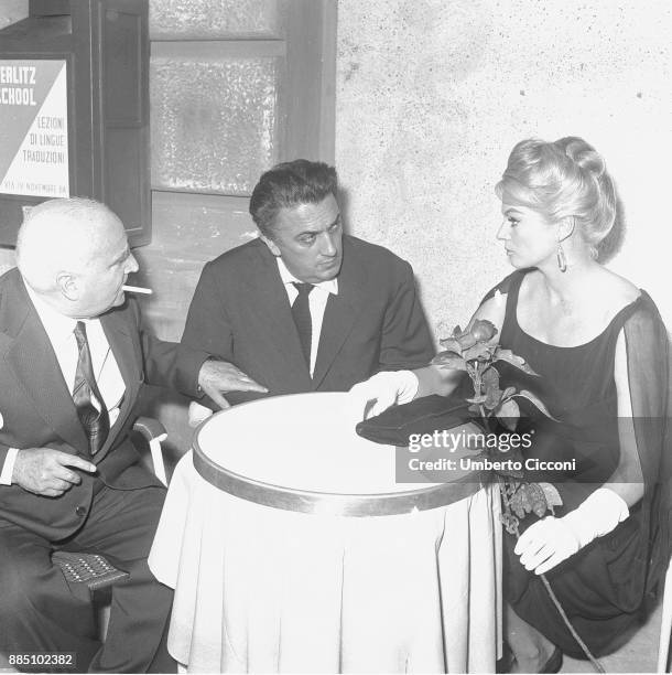 Italian film director Federico Fellini is with actress Anita Ekberg and film producer and publisher Angelo Rizzoli at the cocktail party for 'La...