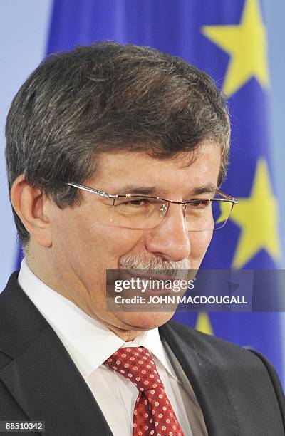 Turkey's Foreign Minister Ahmet Davutoglu stands in front of the European flag as he addresses a press conference following talks with German Foreign...