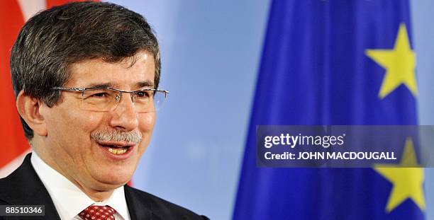 Turkey's Foreign Minister Ahmet Davutoglu next the European flag as he addresses a press conference following talks with German Foreign Minister...