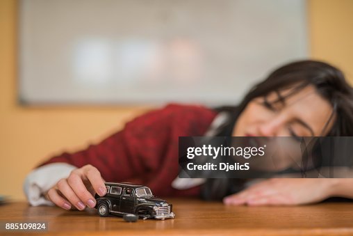 Young woman playing with a car toy. Young woman playing with a car toy.
