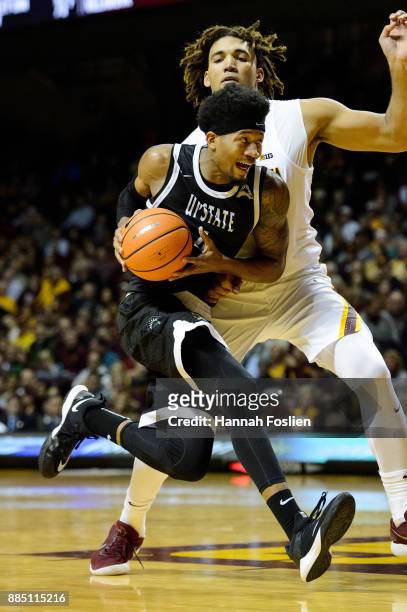 Ramel Thompkins of the USC Upstate Spartans drives to the basket against Reggie Lynch of the Minnesota Golden Gophers during the game on November 10,...