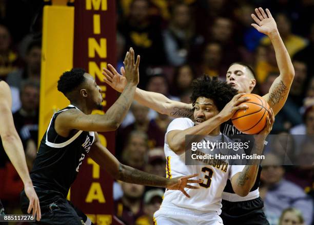 Malik Moore and Carson Smith of the USC Upstate Spartans defend against Jordan Murphy of the Minnesota Golden Gophers during the game on November 10,...