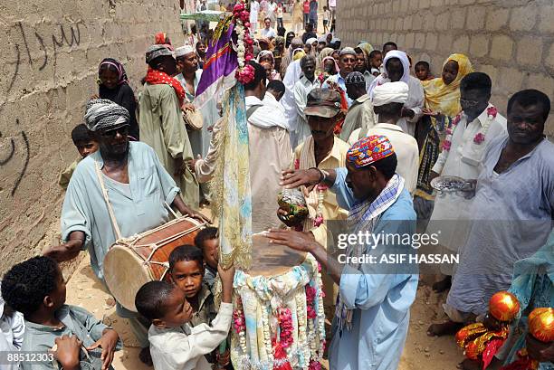 Pakistani devotees gather and sing songs on the third day of the Sheedi festival at the Manghopir Shrine on the outskirts of Karachi on June 16,...