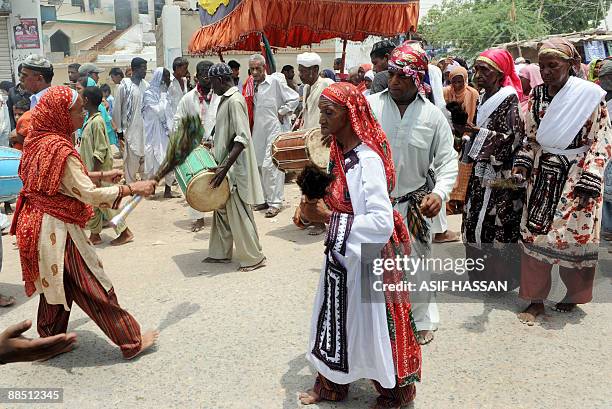 Pakistani devotees beat drums as they sing and dance on the third day of the Sheedi festival at the Manghopir Shrine on the outskirts of Karachi on...