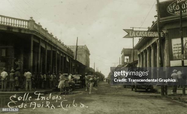 View of pedestrians and cars along Calle Independencia, Ciego de Avila, Cuba, 1930s.