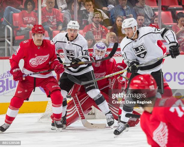 Jimmy Howard of the Detroit Red Wings looks for the puck as teammate Xavier Ouellet of the Wings battles in front with Tanner Pearson and Nick Shore...