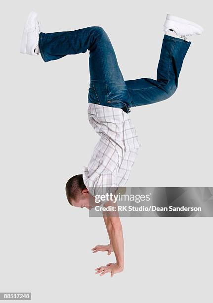 young man doing handstand - handstand fotografías e imágenes de stock