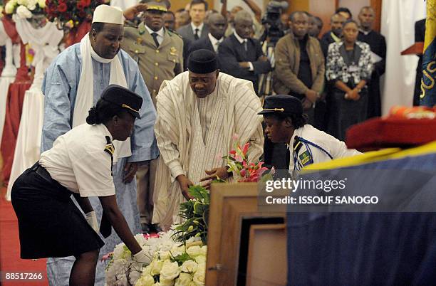 President Amadou Toumani Toure of Mali and Mali former President Alpha Omar Konare pay their respects at the coffin of former President Omar Bongo in...