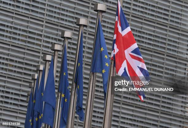 This photo taken on December 4, 2017 shows the British flag displayed next to flags of the European Union in front of the European Union Commission...