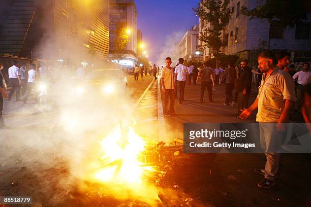 Supporter of defeated Iranian presidential candidate Mir Hossein Mousavi watch a burning Iranian riot-police motorcycle during protests June 16, 2009...