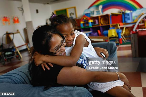 Coulet Johnson, age 9, hugs childcare coordinator Stela Rangel at the Family Gateway family homeless shelter on June 15, 2009 in Dallas, Texas. More...