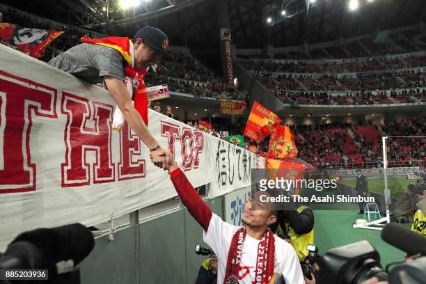 Taishi Taguchi of Nagoya Grampus shakes hands with a supporters as they celebrate the promotion to the J1 after the J.League J1 Promotion Play-Off...