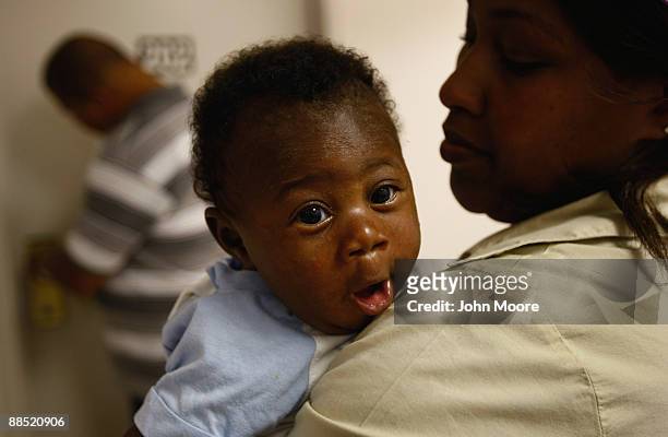 Two-month-old Christian Williams waits with his mother Mecko Hubbert outside their room at the Family Gateway family homeless shelter on June 15,...