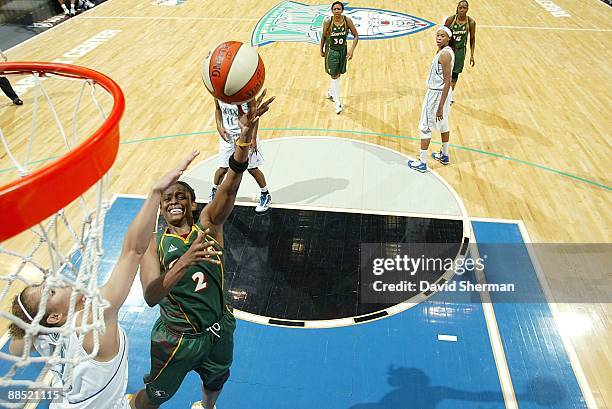 Swin Cash of the Seattle Storm hooks a shot over Christi Thomas of the Minnesota Lynx during the WNBA game on June 12, 2009 at Target Center in...