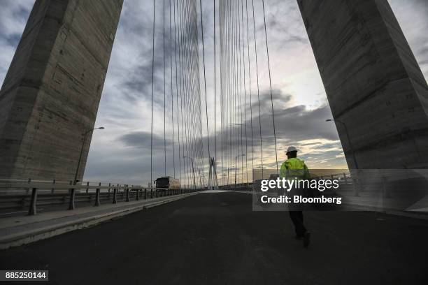 An employee walks along the vehicle deck during maintenance duties on the Yavuz Sultan Bridge, also known as the 3rd Bosporus Bridge, in Istanbul,...