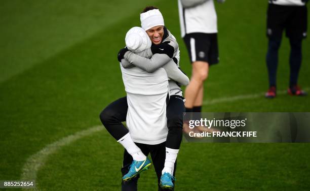 Paris Saint-Germain's Brazilian forward Neymar reacts with Paris Saint-Germain's Brazilian defender Marquinhos during a training session in...