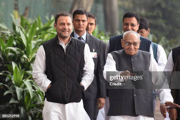 Indian Congress Party Vice President Rahul Gandhi walks with party leader Motilal Vora as he arrives to file his nomination papers for the post of...