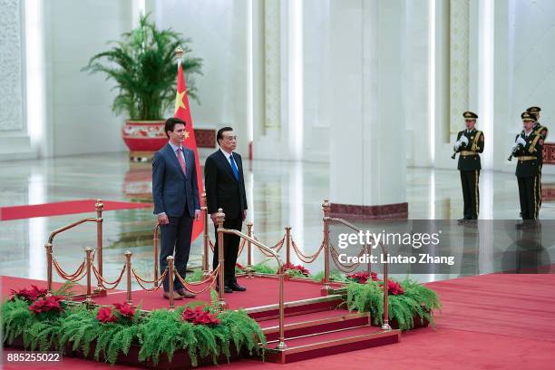 Chinese Premier Li Keqiang and Canada's Prime Minister Justin Trudeau listen to their national anthems during a welcoming ceremony inside the Great...