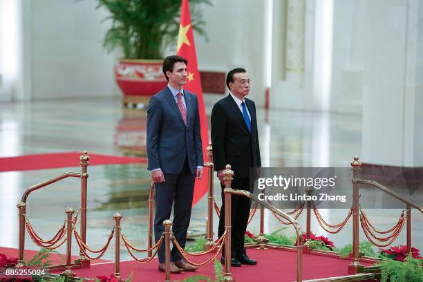 Chinese Premier Li Keqiang and Canada's Prime Minister Justin Trudeau listen to their national anthems during a welcoming ceremony inside the Great...