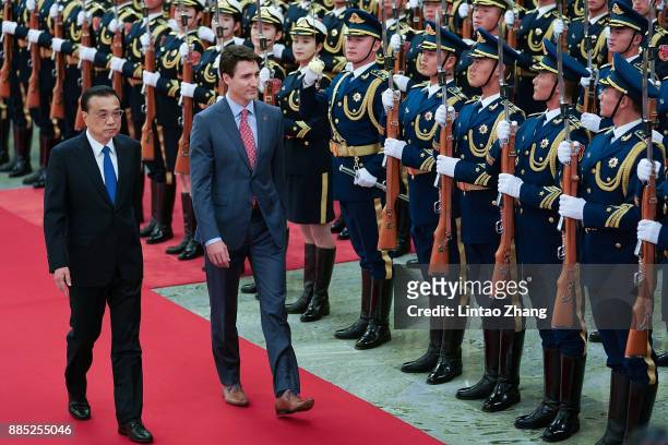 Chinese Premier Li Keqiang accompanies Canada's Prime Minister Justin Trudeau to view an honour guard during a welcoming ceremony inside the Great...