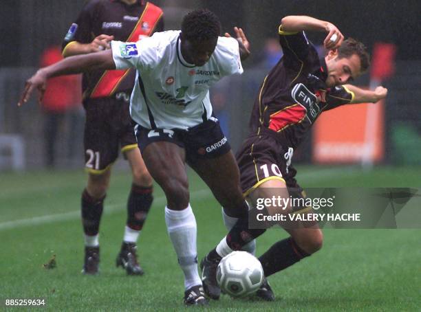 Le milieu de terrain rennais, Philippe Delaye , tente de récuperer le ballon au défenseur troyen, Seikou Berthe , le 10 août 2002 au stade de Rennes,...