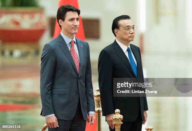 Chinese Premier Li Keqiang and Canada's Prime Minister Justin Trudeau listen to their national anthems during a welcoming ceremony inside the Great...