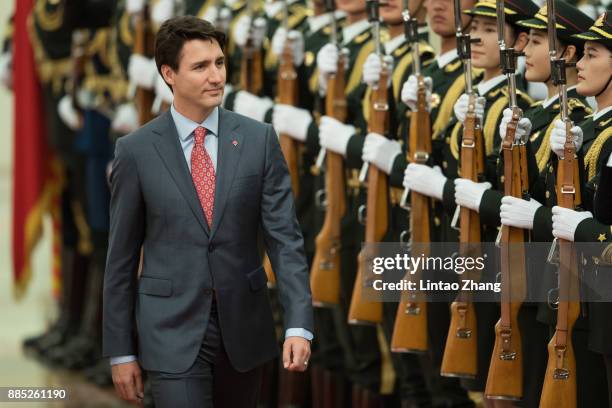 Chinese Premier Li Keqiang accompanies Canada's Prime Minister Justin Trudeau to view an honour guard during a welcoming ceremony inside the Great...