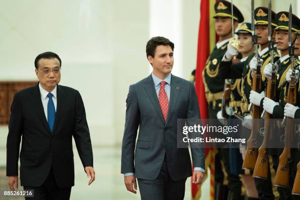 Chinese Premier Li Keqiang accompanies Canada's Prime Minister Justin Trudeau to view an honour guard during a welcoming ceremony inside the Great...