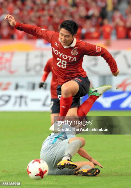 Ryuji Izumi of Nagoya Grampus is tackled by Koji Yamase of Avispa Fukuoka during the J.League J1 Promotion Play-Off Final between Nagoya Grampus and...