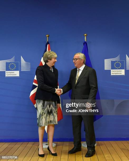 British Prime Minister Theresa May and European Commission chief Jean-Claude Juncker shake hands prior to a Brexit negotiation meeting on December 4,...