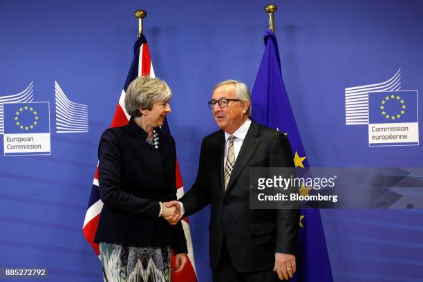 Theresa May, U.K. Prime minister, left, shakes hands and speaks with Jean-Claude Juncker, president of the European Commission, as they pose for...