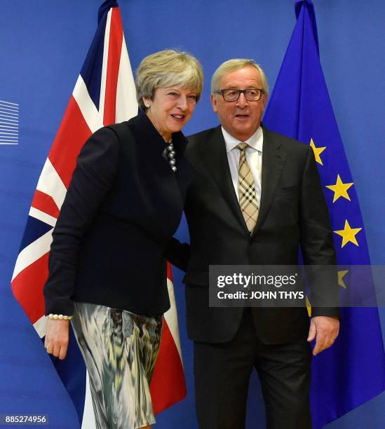 British Prime Minister Theresa May and European Commission chief Jean-Claude Juncker pose prior to a Brexit negotiation meeting on December 4, 2017...