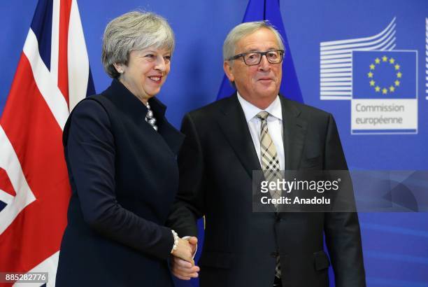 British Prime Minister Theresa May and European Commission Chief Jean-Claude Juncker shake hands as they pose prior to a Brexit negotiation meeting...