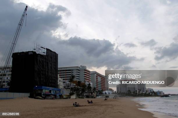 People are seen at the beach in the tourist zone of El Condado in San Juan, Puerto Rico on November 28, 2017. / AFP PHOTO / Ricardo ARDUENGO / TO GO...