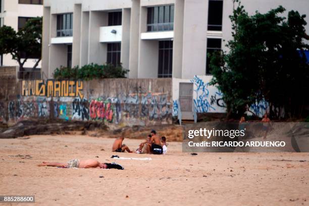 People are seen at the beach in the tourist zone of El Condado in San Juan, Puerto Rico on November 28, 2017. / AFP PHOTO / Ricardo ARDUENGO / TO GO...