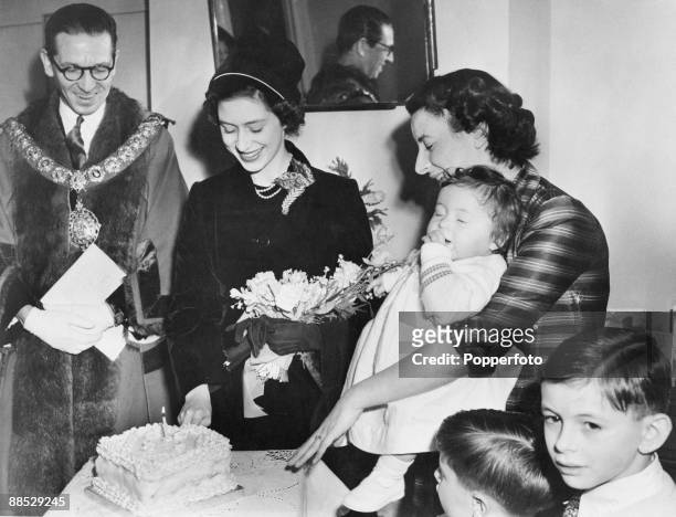 Princess Margaret cuts the cake at Sharon Shipman's first birthday party, during a visit to the Shipman family home at 25 Amwell Court, Stoke...