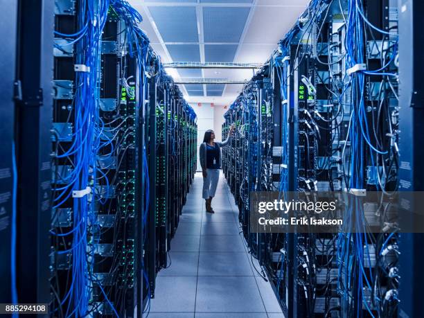 woman standing in aisle of server room - big tech 個照片及圖片檔