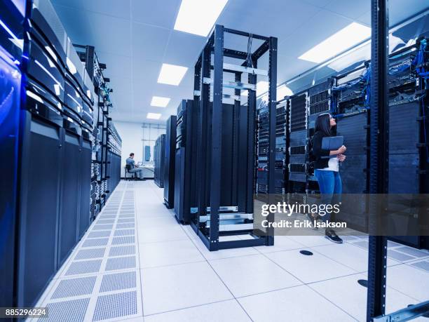 woman and man working in server room - datacenter fotografías e imágenes de stock