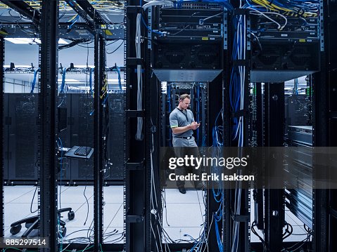 Man using mobile phone in server room Man using mobile phone in server room