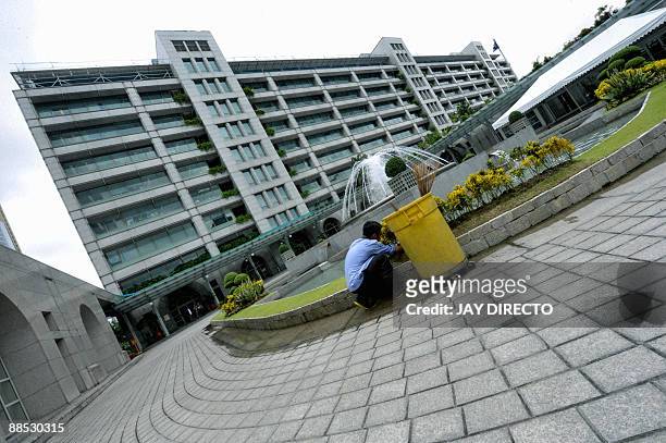 Worker cleans the ground of the Asian Development Bank headquarters in Manila on June 17 where an international conference on climate change is being...