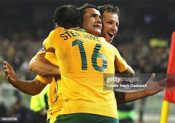 Tim Cahill of the Socceroos celebrates his second goal with team mates Mile Sterjovski and Lucas Neil during the 2010 FIFA World Cup Asian qualifying...