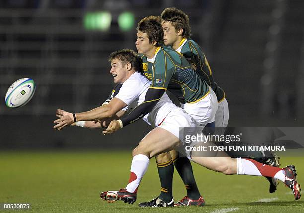 England's Henry Trinder passes the ball during a tackle by South African players during the first half of their semi-final match in the 2009 IRB...
