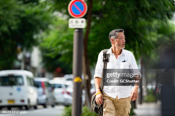 忙しい一日の後ハンサムな日本人男の家から歩いて戻って - 追う ストックフォトと画像