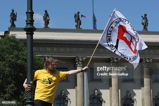 Young man waving a flag joins striking students protesting in front of Humboldt University on June 17, 2009 in Berlin, Germany. Thousands of students...