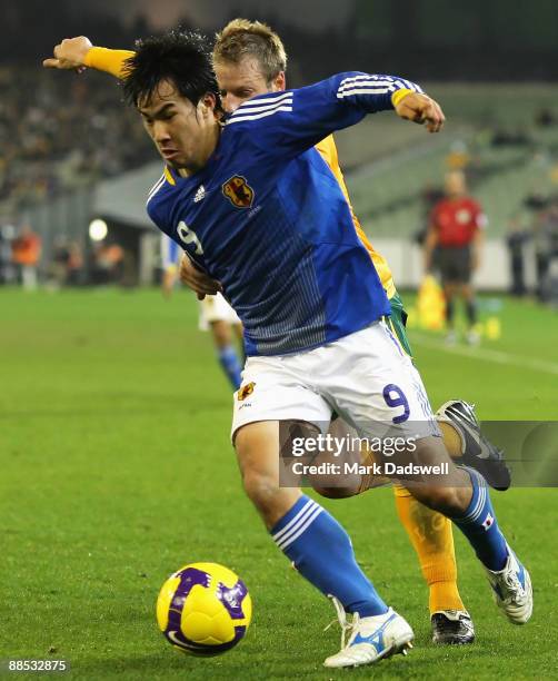 Shinji Okazaki of Japan controls the ball ahead of Vince Grella of the Socceroos during the 2010 FIFA World Cup Asian qualifying match between the...