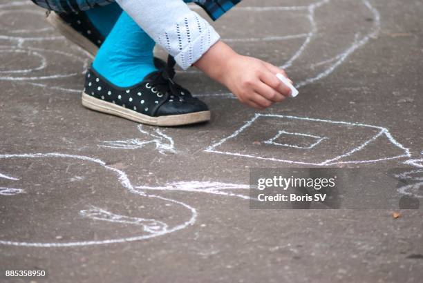 girl drawing house on asphalt with chalk - 9 hand drawn patterns stock-fotos und bilder