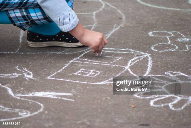 girl drawing house on asphalt with chalk - 9 hand drawn patterns stock-fotos und bilder