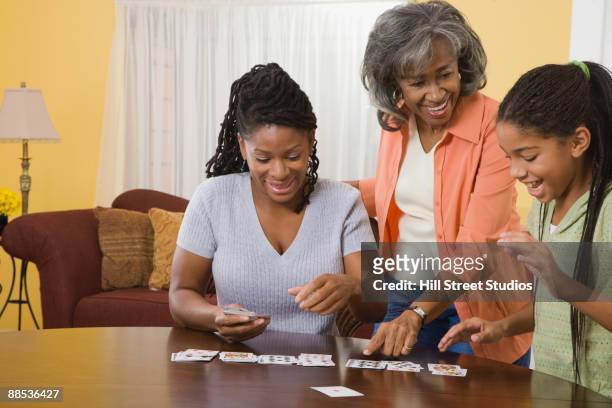 african family playing cards together - card game mature people stock-fotos und bilder