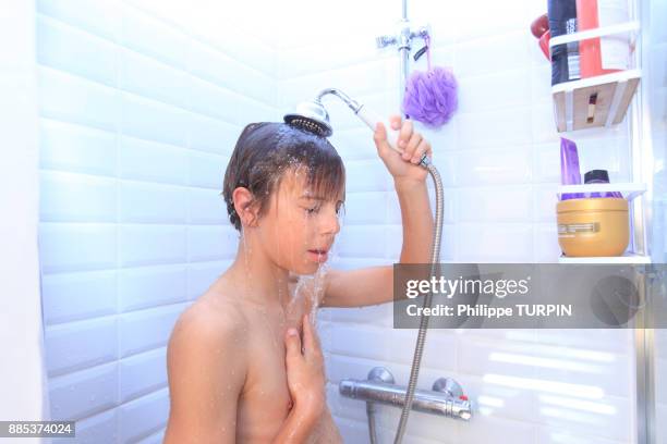 france, young boy in the bathroom taking shower. - kids taking a shower stockfoto's en -beelden